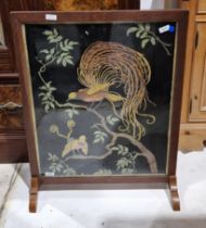 Early 20th century oak framed firescreen having a needlework panel decorated with exotic birds