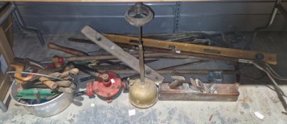 Collection of garden and workshop tools including hoes, pick axe, spirit levels, woodworking planes,