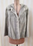 A grey mink jacket, shawl collar, side pockets, labelled Howell's Cardiff, size medium