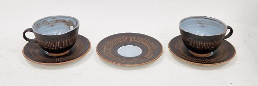 Pair of Dieter Kunzemann cups and saucers, black glaze with sgraffito decoration on pale blue