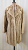 A three-quarter length pale tan mink jacket, embroidered satin lining, button detail to the cuffs