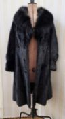 A black mink coat, with a fox fur collar, button detail to the hook fastening, labelled Harrods,