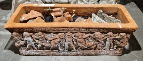 A terracotta rectangular garden planter decorated with moulded cherubs, with four lion's head