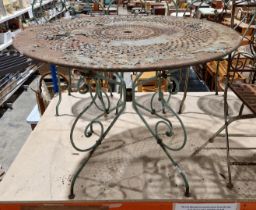A scrolled wrought iron garden table with circular pierced top, painted pale green, 97cm dia x