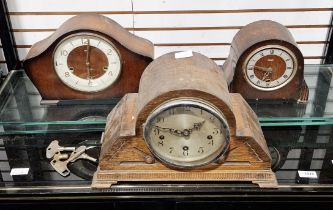 Three early 20th-century domed-topped mantel clocks, two oak-cased, one walnut