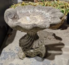 V A reconstituted stone bird bath in the form of a scallopshell on a four-footed wrythen column base