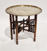 Middle Eastern brass tray top table, on a wooden folding base, 57cm high x 59cm diameter