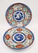 Pair of Japanese Meiji period large Imari chargers, both painted in underglaze blue to the centre,