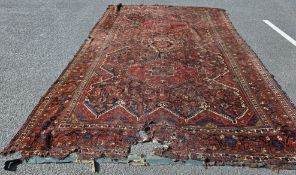 Very large Eastern red ground carpet with central floral motif enclosed by two large lozenge