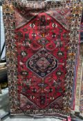 Persian style red ground rug with central geometric motif on geometric shape field, geometric