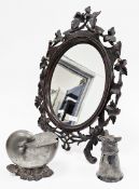 Black Forest easel-back dressing mirror, of oval form, the wooden frame carved with scrolls and