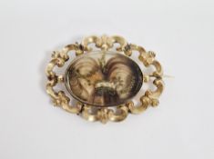 Victorian gold-coloured metal mourning brooch, oval, inset with hair to the central glass panel, C-