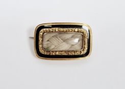 Early 19th century gold-coloured metal and black enamel mourning brooch, rounded rectangular inset