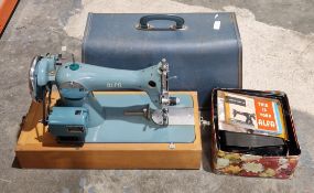 A cased 1960's electric sewing machine by Alfa, with Sew-Tric Ltd. motor, together with a tin of
