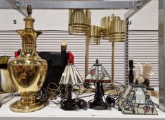 V Three Tiffany-style table lamps, the leaded coloured shades on bronze effect bases, together