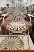 Wrought iron garden elbow chair with a white finish, the circular back and seat with a star-burst