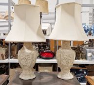 Pair of white glazed ceramic table lamps in the Chinese-style with relief decoration, with shades,