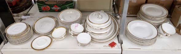 Matched set of white glazed dinnerware with gold and Greek key patterned rims, makes including