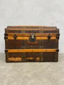 A late 19th century beech slatted, metal and brass bound traveling trunk with fitted section to