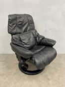 A vintage black leather upholstered stressless reclining swivel armchair with makers marks. Seat