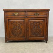 A C.1900 oak dresser base or sideboard with two fluted frieze drawers above two carved panel doors