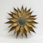 A contemporary gold painted sheet metal sunflower or starburst wall mirror with circular plate. H.