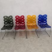 A set of four contemporary Italian Diva dining chairs each with openwork polycarbonate back and seat