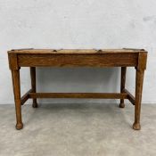 An early 20th century oak hotel luggage rack or bench having slatted top with brass straps raised on