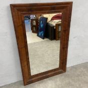 A 19th century American Empire wall mirror with rectangular plate in a shaped flame mahogany