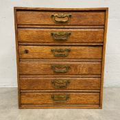 An early 20th century oak tabletop filing cabinet with six brass mounted drawers raised on a