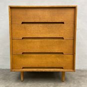 A mid-century Stag 'C' range oak chest of four long drawers raised on circular tapered supports by