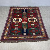 A Caucasian Kazak carpet with two rows of six polychrome guls over a royal blue ground within