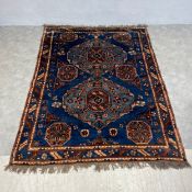 An Afghan Baluchi carpet with two central diamond lozenge medallions over a royal blue abrash ground