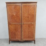 A 19th century French walnut wardrobe in the Louis XV style with shaped cornice over a pair of