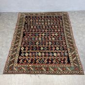 A Caucasian Shirvan carpet with polychrome flowerhead pattern field over a midnight ground within