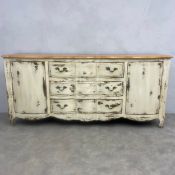 A contemporary French Provincial style sideboard in a distressed painted finish. H.96 W.200 D.50cm.
