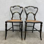 A pair of Victorian ebonised side chairs each with hand painted and gilt back over the serpentine