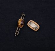 A yellow metal bar brooch with red cabochon stone together with a yellow metal mourning brooch