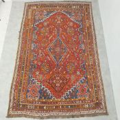 A hand knotted Persian Qashqai carpet with central pole medallion and floral field with stepped