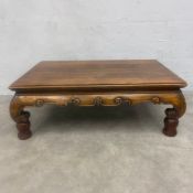 A 20th century Chinese hardwood low Kang coffee table with thumb moulded top over the carved apron