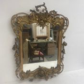 A 19th century Rococo style carved giltwood wall mirror with scrolling shell and foliate cresting