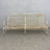 A French 19th century white painted wrought iron strap-work garden or outdoor bench with scrolled