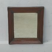 A 19th century wall mirror with original plate in a simple mahogany frame. H.47 W.42cm