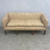 A Georgian two seater sofa with square damask upholstered back, arms and seat raised on straight