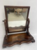 A C.1900 mahogany vanity mirror with swing action raised on a shaped plinth base on carved feet. H.