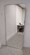 A large contemporary wall hanging mirror with shaped plate in a brass slip frame. H.200 W.90cm (with