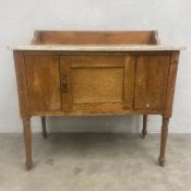 A C.1900 oak washstand with white marble top and shaped gallery back over the single panel