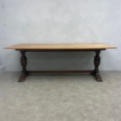 A 20th century Jacobean style oak refectory dining table with plank top raised on heavy turned and