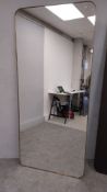 A large contemporary wall hanging mirror with shaped plate in a brass slip frame. H.200 W.90cm (with