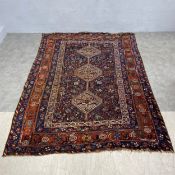 A Persian Khamseh carpet with central pole medallion in a polychrome field over a midnight ground